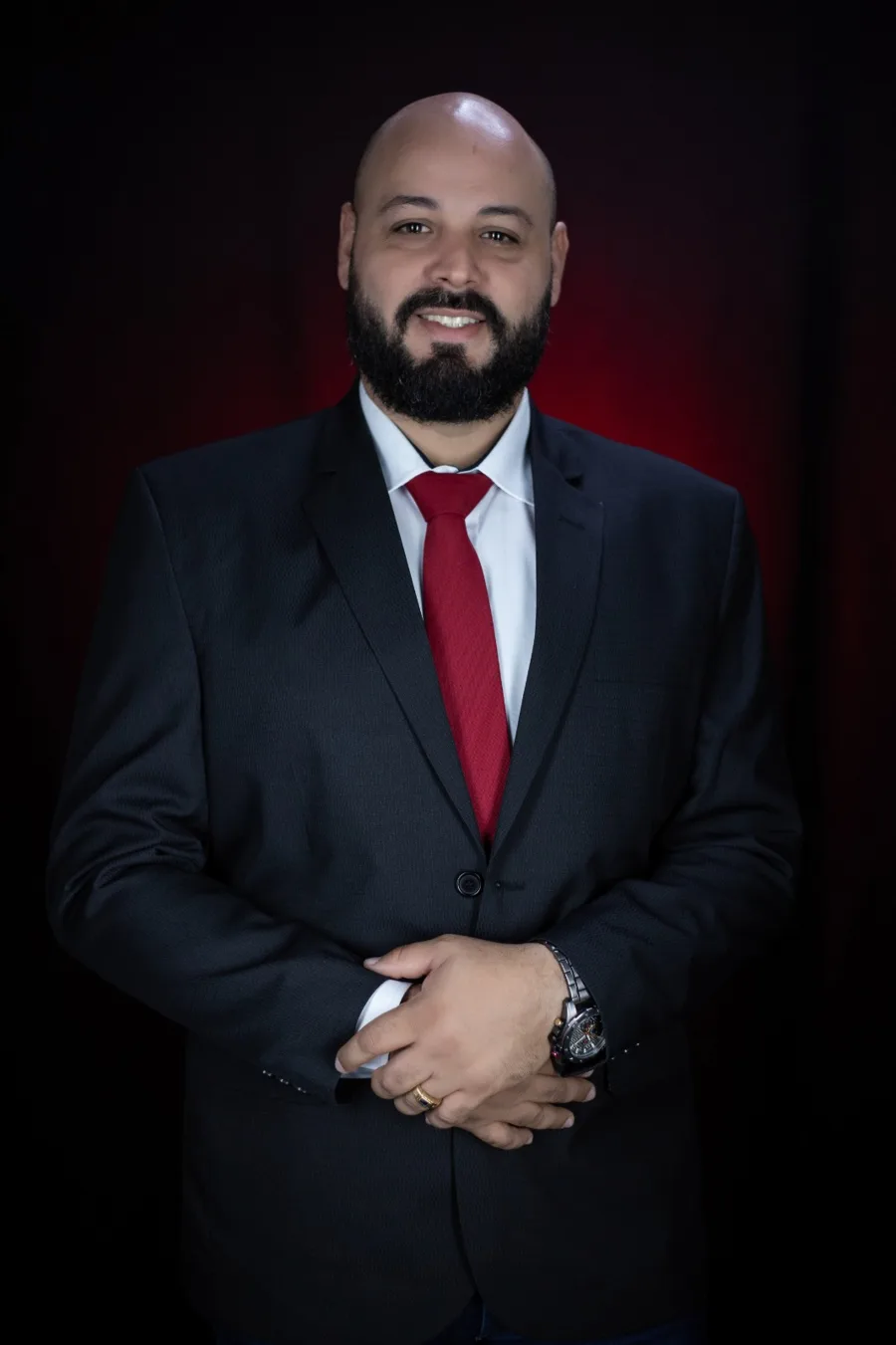 Dr. Tiago Nascimento, advogado, de terno escuro e gravata vermelha